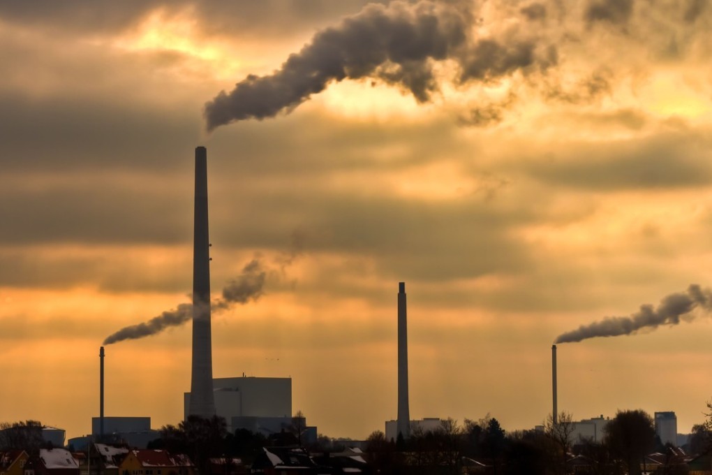 A power plant belches smoke into a yellow sky. Photo: Alamy