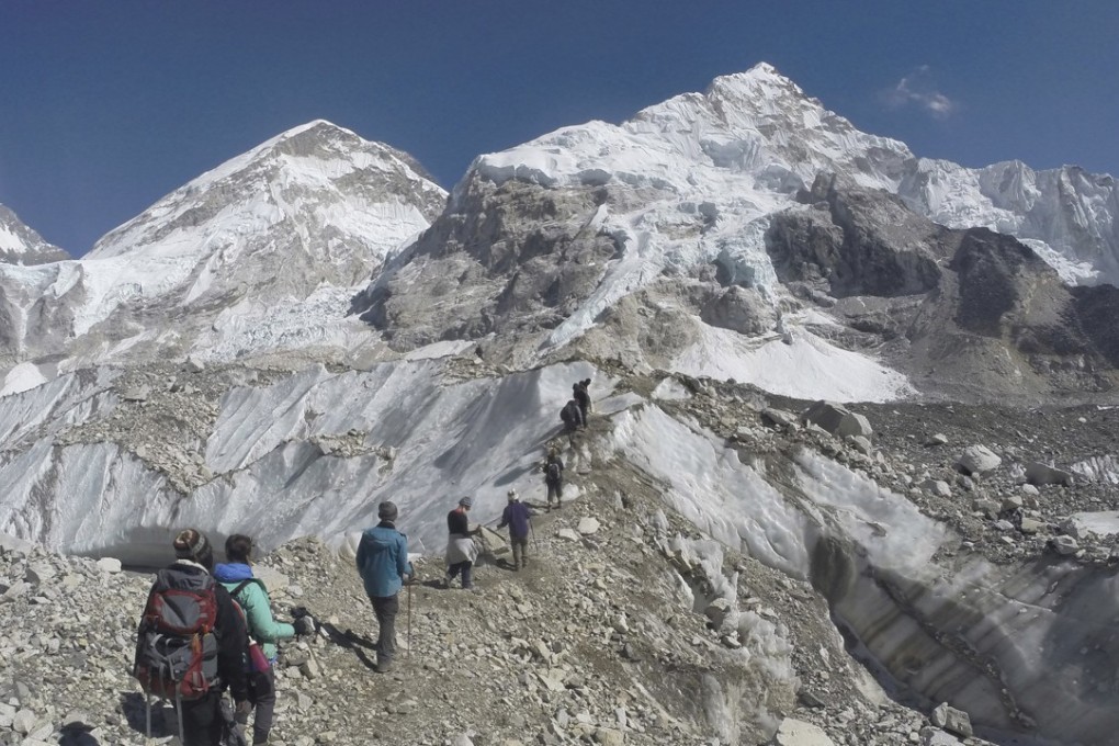 International trekkers pass through a glacier at the Mount Everest base camp, Nepal. Scientists say a third of the ice stored in Asia’s glaciers will be lost by the end of the century even if global warming stays below 1.5 degrees Celsius. Photo: AP