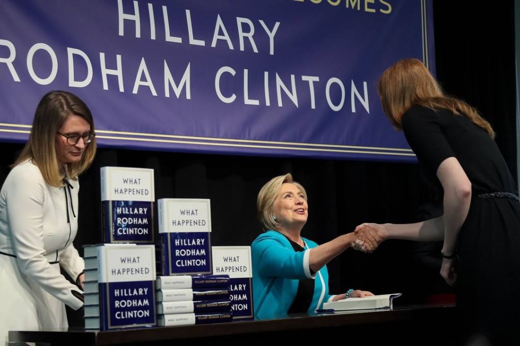 Hillary Clinton signs copies of her new book. Photo: AFP