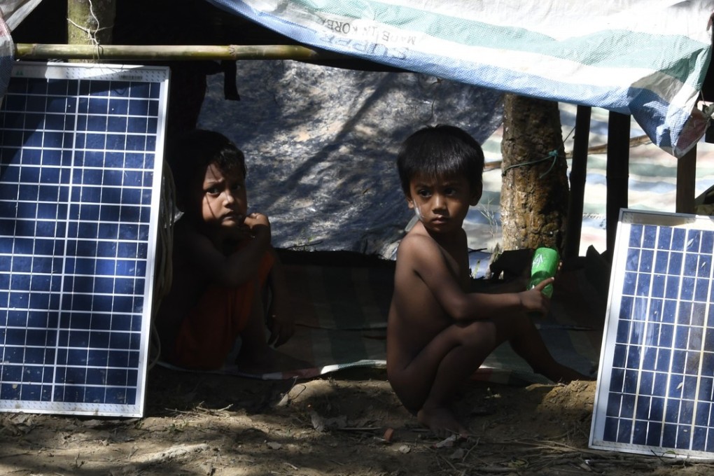 Rohingya refugee children sit next to solar panels by their shelter in Bangladesh’s Balukhali refugee camp on Friday. China has promised to send aid to help the hundreds of thousands of Rohingya who have fled Myanmar. Photo: AFP