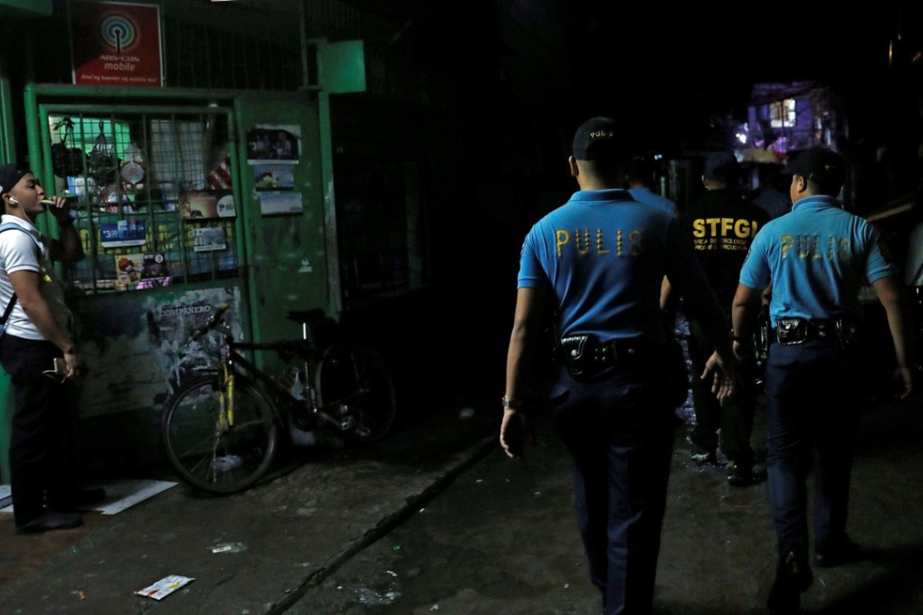 Policemen from Caloocan Police District patrol a dimly lit alley at a residential district in Caloocan City. Photo: Reuters