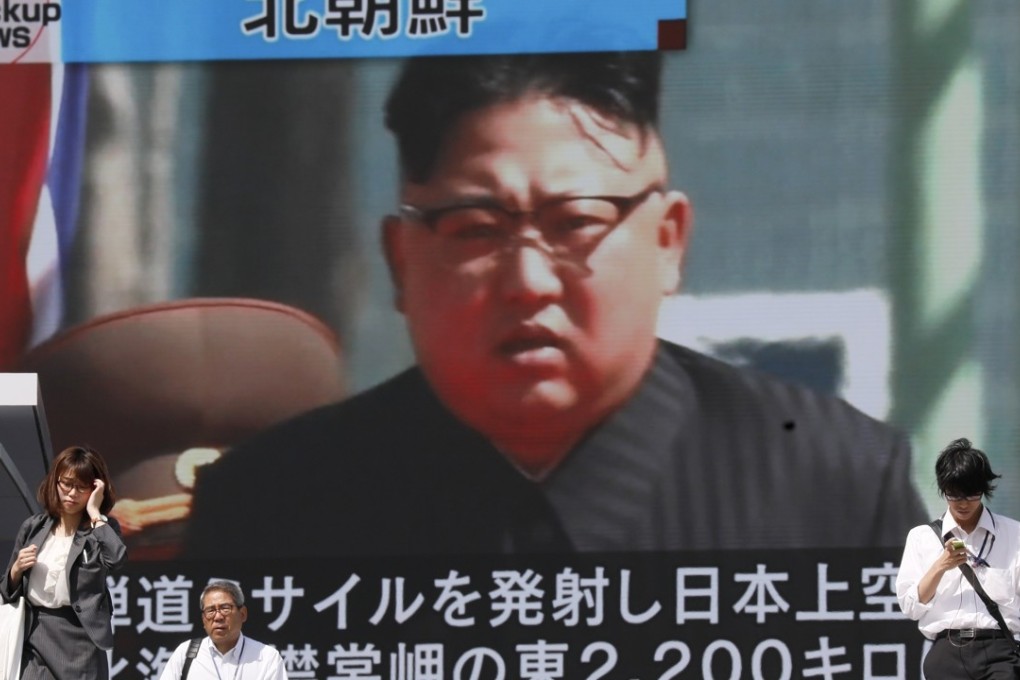 Pedestrians walk under a huge monitor displaying North Korean leader Kim Jong-un on a TV news broadcast in Tokyo, Japan on Friday. Earlier in the day, Pyongyang launched a ballistic missile over Japan that reportedly crashed in the Pacific Ocean. Photo: EPA