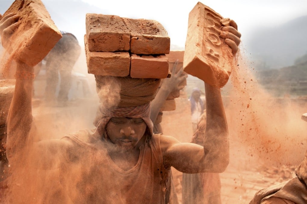 Stacking – Nepal: a brick kiln in Nepal. Each brick weighs about 2kg. The dust goes straight into the slaves’ lungs. Picture: Lisa Kristine
