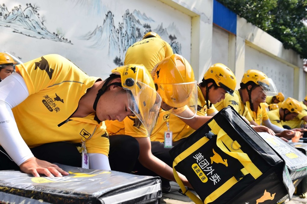 Meituan delivery staff in the eastern city of Jinan prepare their orders. Photo: Xinhua