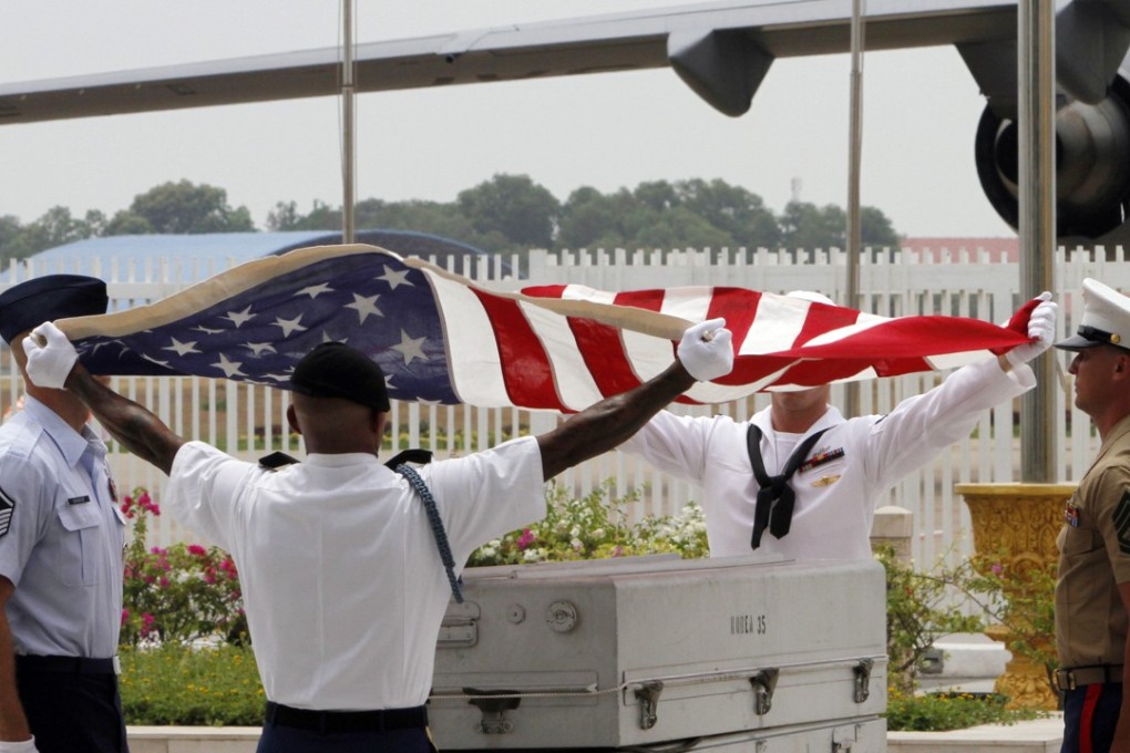 US military personnel drape a flag over a coffin containing the remains of a US serviceman during a repatriation ceremony at Phnom Penh International Airport in 2014. File photo: AP