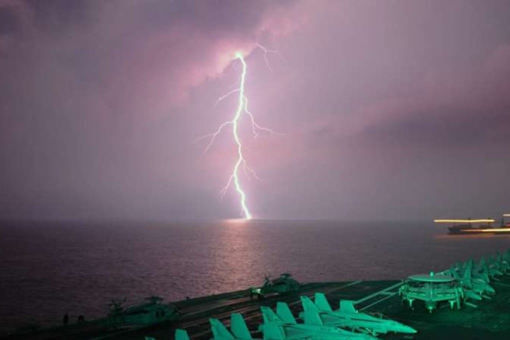 Lightning behind an aircraft carrier in the Strait of Malacca. New research finds lightning strikes occurred nearly twice as often directly above heavily-trafficked shipping lanes in the Indian Ocean and the South China Sea year-round from 2005 through 2016. Photo: Handout.
