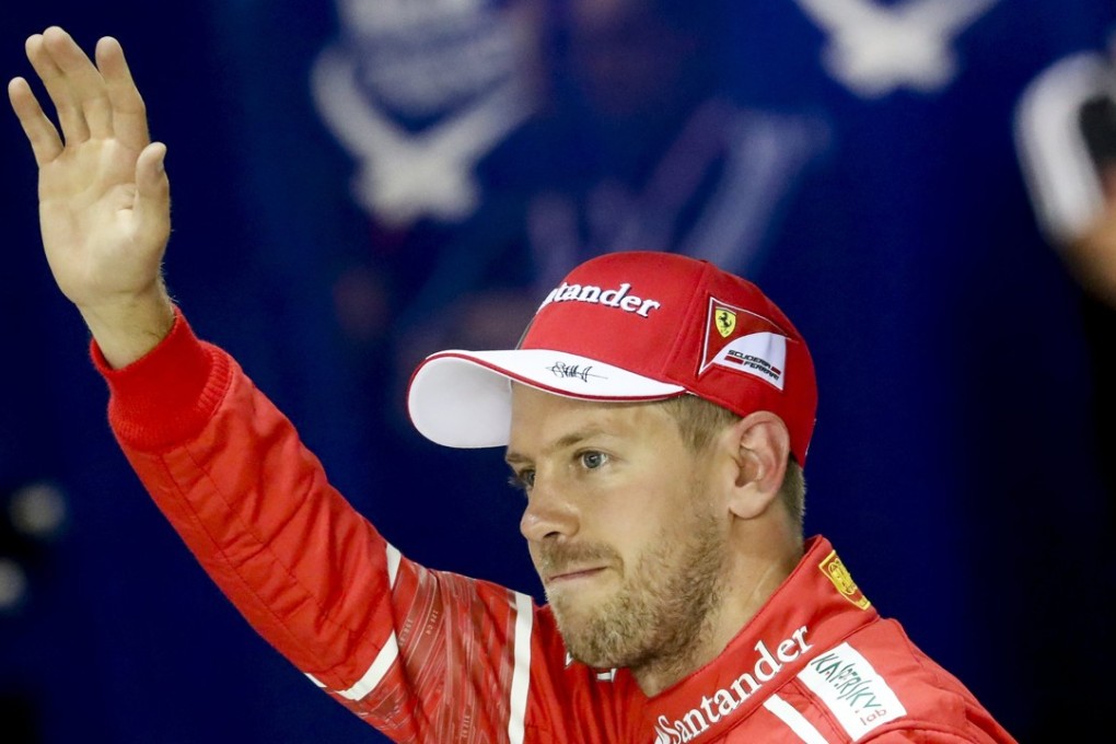 Sebastian Vettel of Ferrari reacts on the parc ferme after taking pole position during qualifying for the Singapore Formula One Grand Prix at the Marina Bay Street Circuit. Photo: EPA