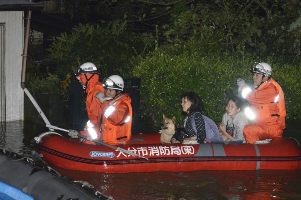 Local residents are evacuated by boat from an inundated house due to a heavy rain triggered by Typhoon Talim, in Oita, southern Japan. Photo: Kyodo