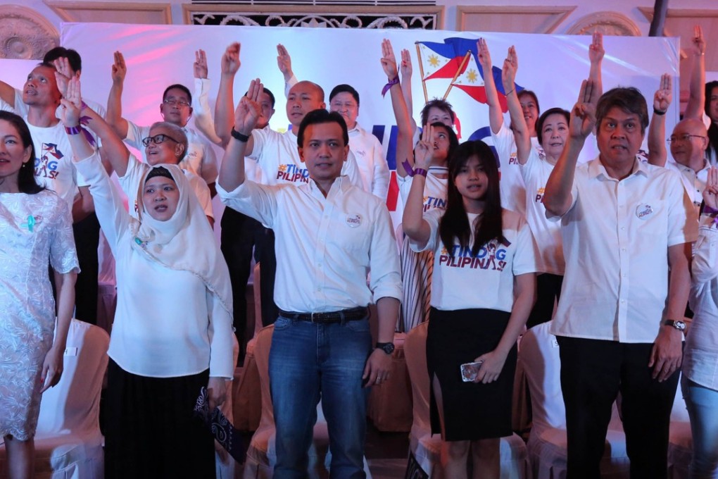 Philippine senators and their supporters raise a three-fingered salute. Photo: AFP