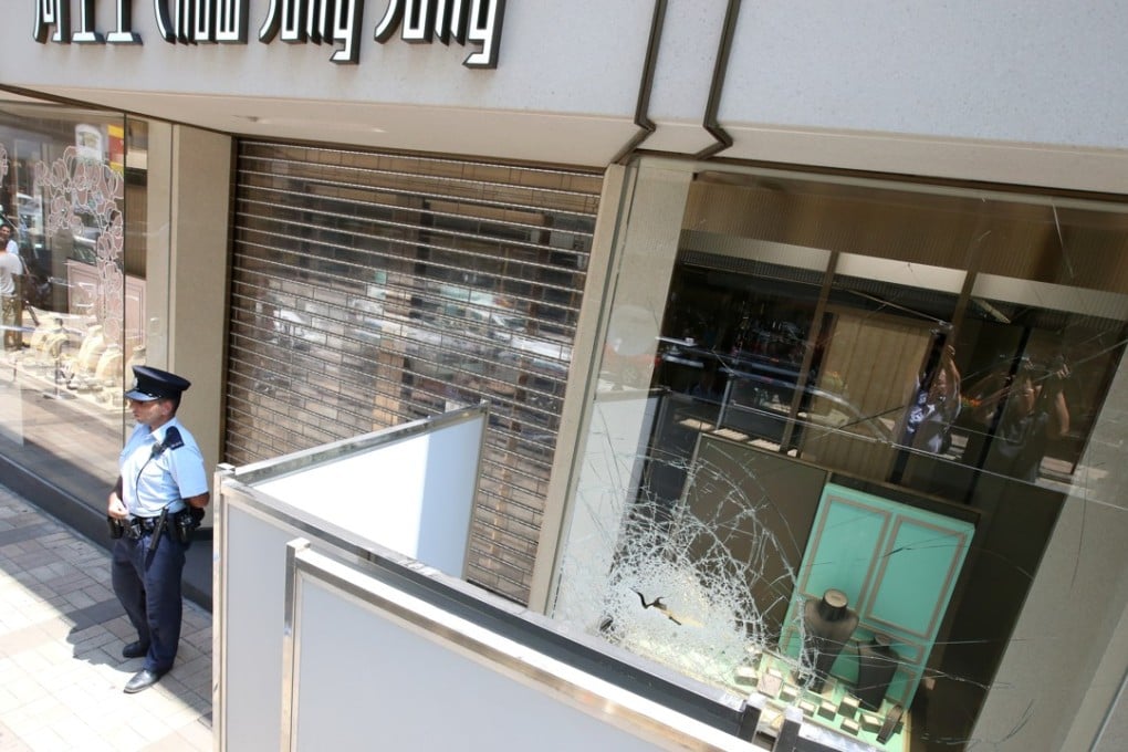 Police officers investigate at the Chow Sang Sang Jewellery shop in Tsim Sha Tsui. Photo: David Wong
