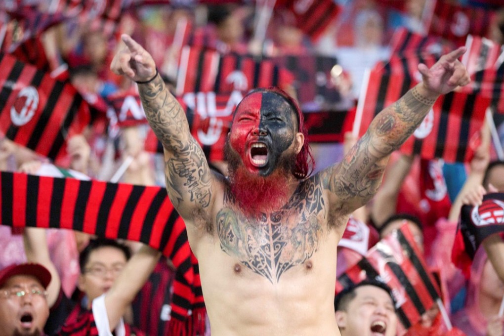 A Chinese AC Milan fan in the crowd during the pre-season friendly match against Borussia Dortmund in Guangzhou. Both Milan clubs are currently under Chinese ownership. Photo: Reuters