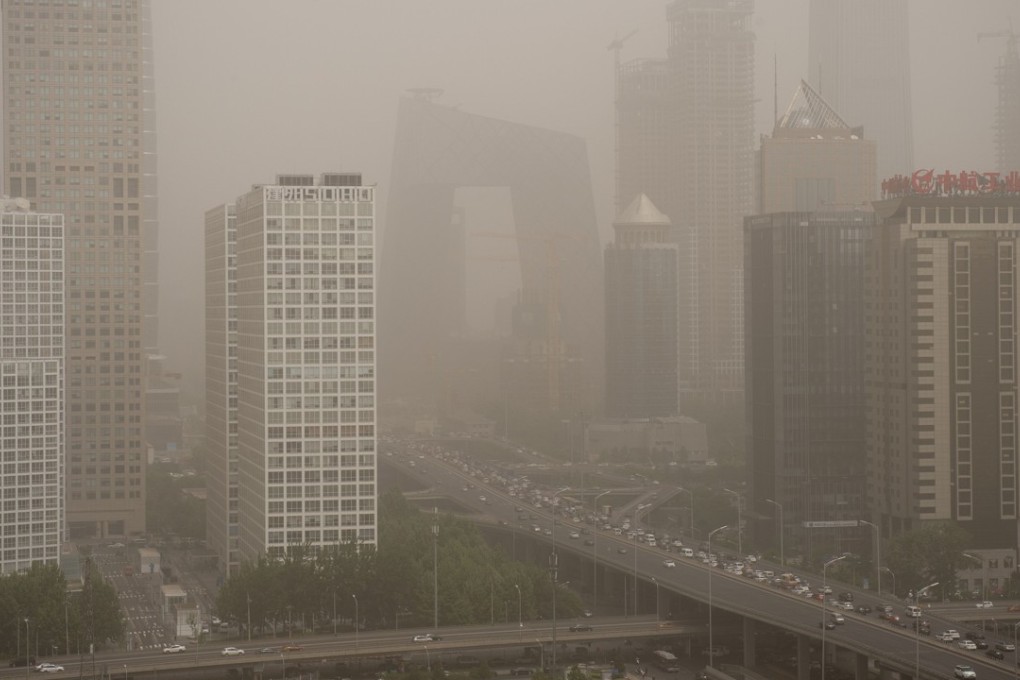 Beijing’s central business district is shrouded in a dust storm on May 4. China, the world's biggest auto market, is considering a ban on fossil fuel cars in a major boost to the production of electric vehicles as it seeks to ease pollution. Photo: AFP