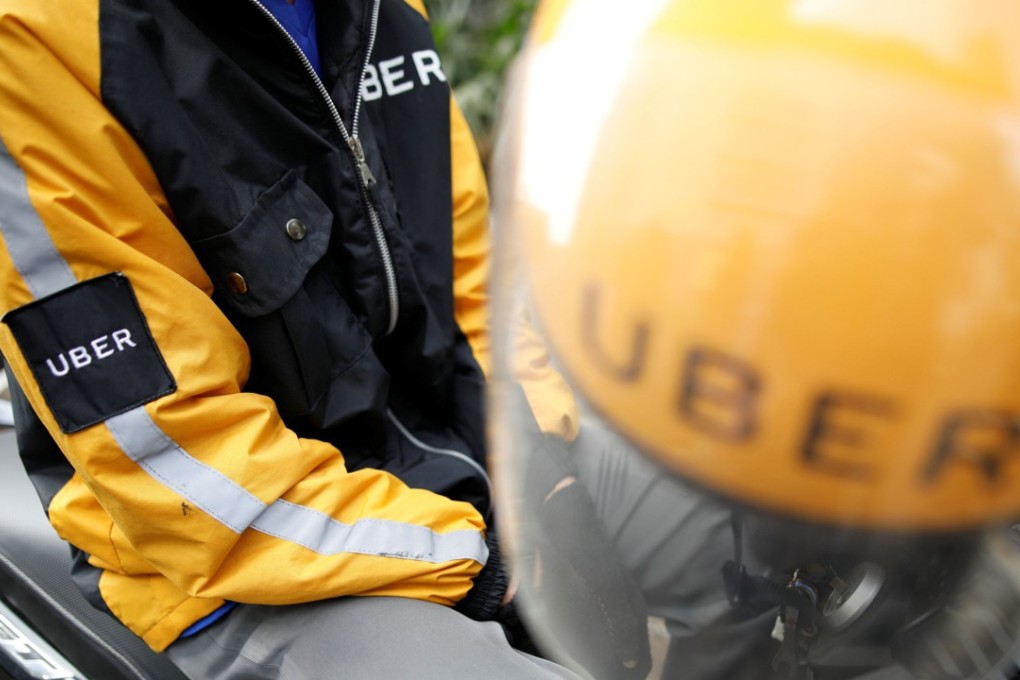 An Uber motorcycle taxi driver waits for customers next to a shopping centre in Jakarta. Photo: Reuters