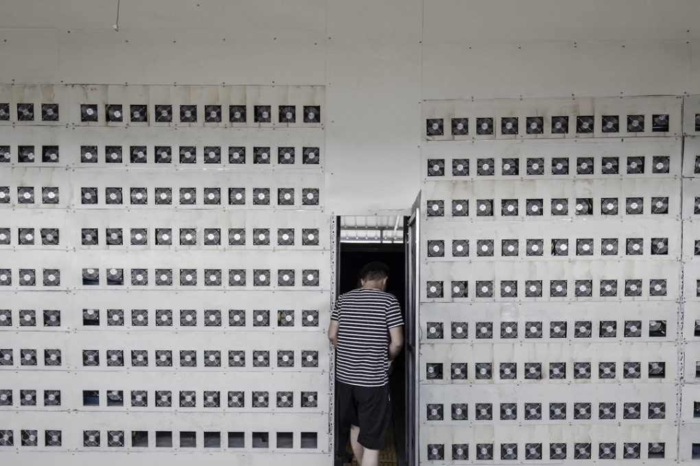 Technicians exit a cooling chamber near a wall of bitcoin mining machines at a mining facility operated by Bitmain Technologies in Inner Mongolia, China. Photo: Bloomberg