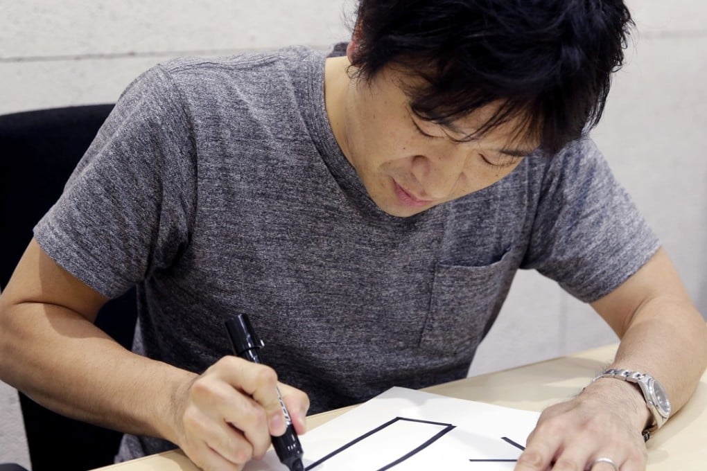 Shigetaka Kurita writes a pictograph. Photo: AP