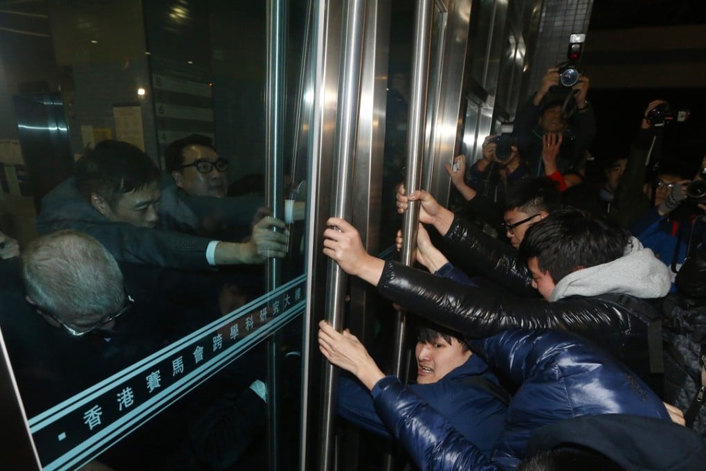 HKU students try to break into the The Hong Kong Jockey Club Building For Interdisciplinary Research on Sassoon Road in Pok Fu Lam, where the council meeting was held. Photo: Sam Tsang