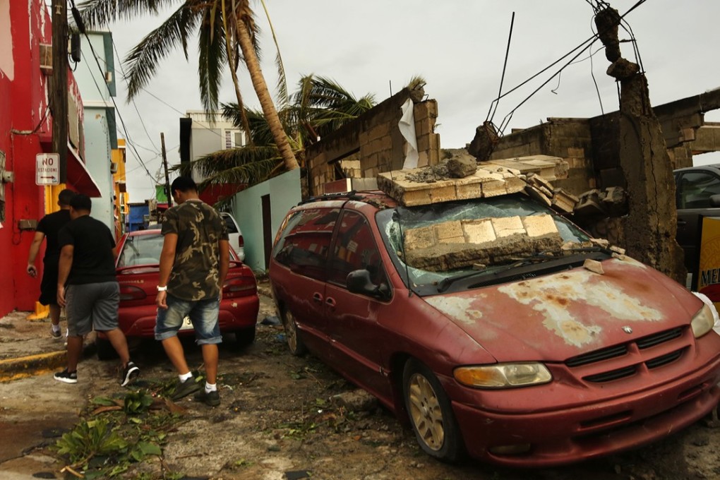 The day after Hurricane Maria made a direct hit on Puerto Rico with winds up to 150mph, residents of La Perla, close to Old San Juan, begin to clean up. Photo: Los Angeles Times/TNS