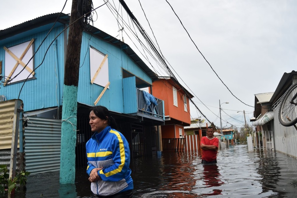 Residents of Puerto Rico walk across a flooded street after Hurricane Maria pummels the island. Photo: AFP