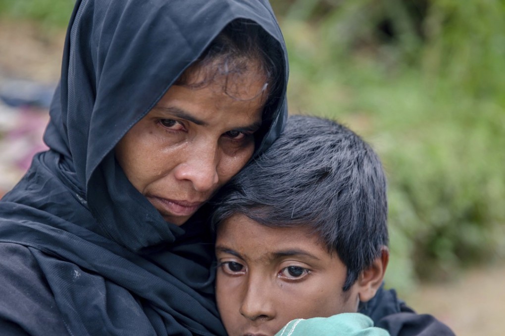 A Rohingya Muslim waits for help to transport her sick son to a nearby clinic in Taiy Khali, Bangladesh, on Wednesday. Photo: AP