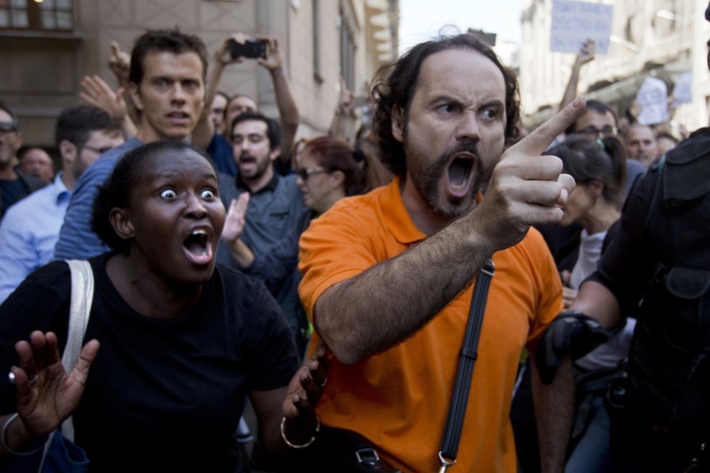 Demonstrators react as they try to stop the car carrying Xavier Puig, a regional Catalan official, after his arrest in Barcelona on Wednesday. Photo: AP