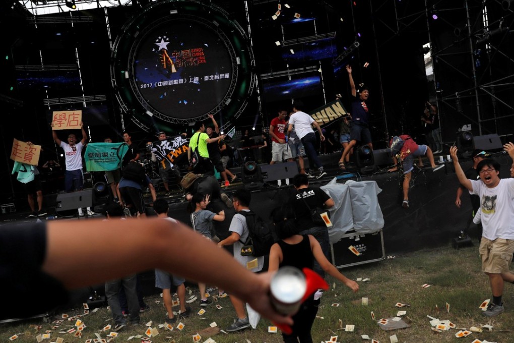 Students climb on stage with Taiwanese independence flags to protest against a popular mainland Chinese talent show, Sing! China, at the National Taiwan University in Taipei. Photo: Reuters