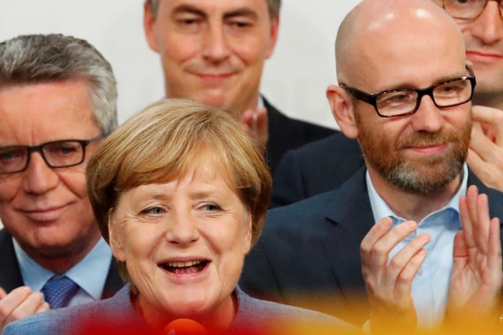 German Chancellor Angela Merkel and members of her ruling coalition react after winning the German general election on Sunday in Berlin. Photo: Reuters