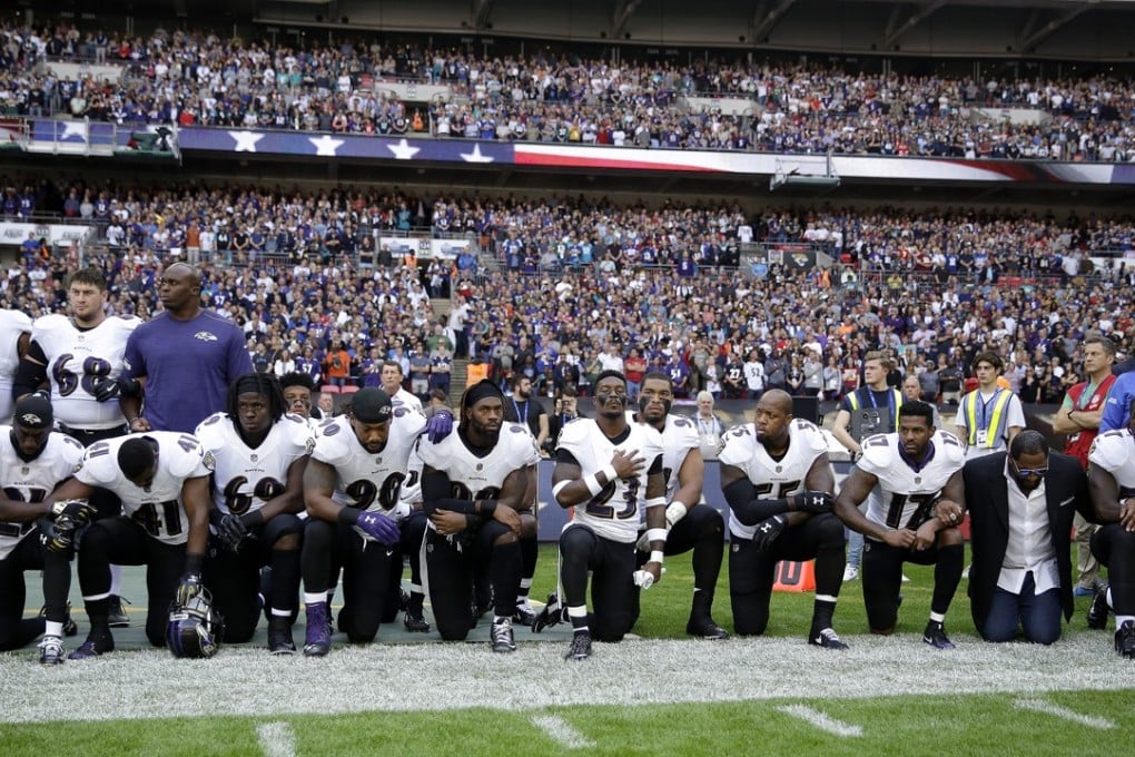 Baltimore Ravens players, and former player Ray Lewis, second from right, kneel during the playing of the US national anthem before an NFL football game against the Jacksonville Jaguars at Wembley Stadium in London, on Sunday. Photo: AP