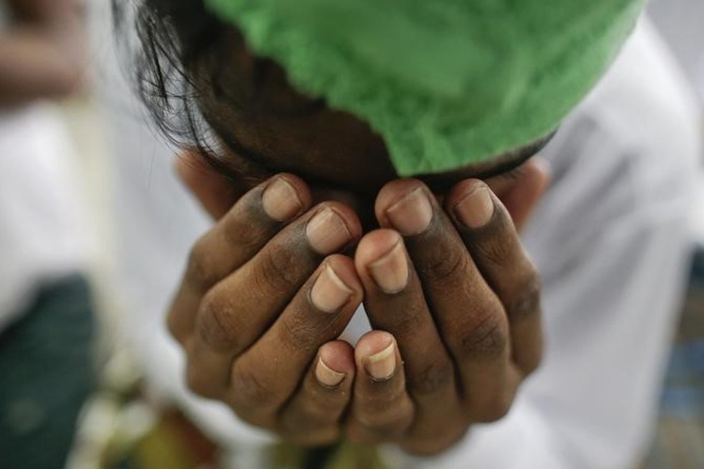 A suspected victim of human trafficking prays at a government shelter in the Takua Pa district of Phang Nga, Thailand, in October 2014. Photo: Reuters