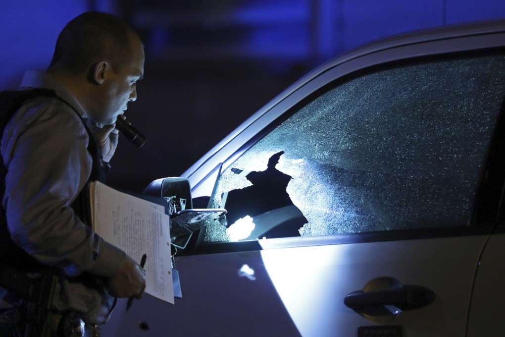 A police detective inspects an SUV that was damaged by bullets at a crime scene in Chicago. Shootings have jumped in the city, which accounts for a large share of murders in the US. Photo: Chicago Tribune via AP