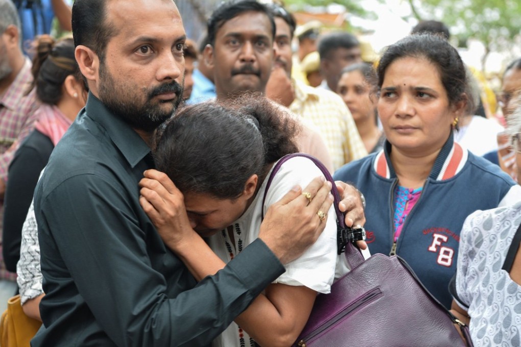 Indian journalist Gauri Lankesh's sister Kavitha Lankesh is consoled by a relative as her body is brought to the Ravindra Kalakshetra cultural centre in Bangalore. Photo: AFP