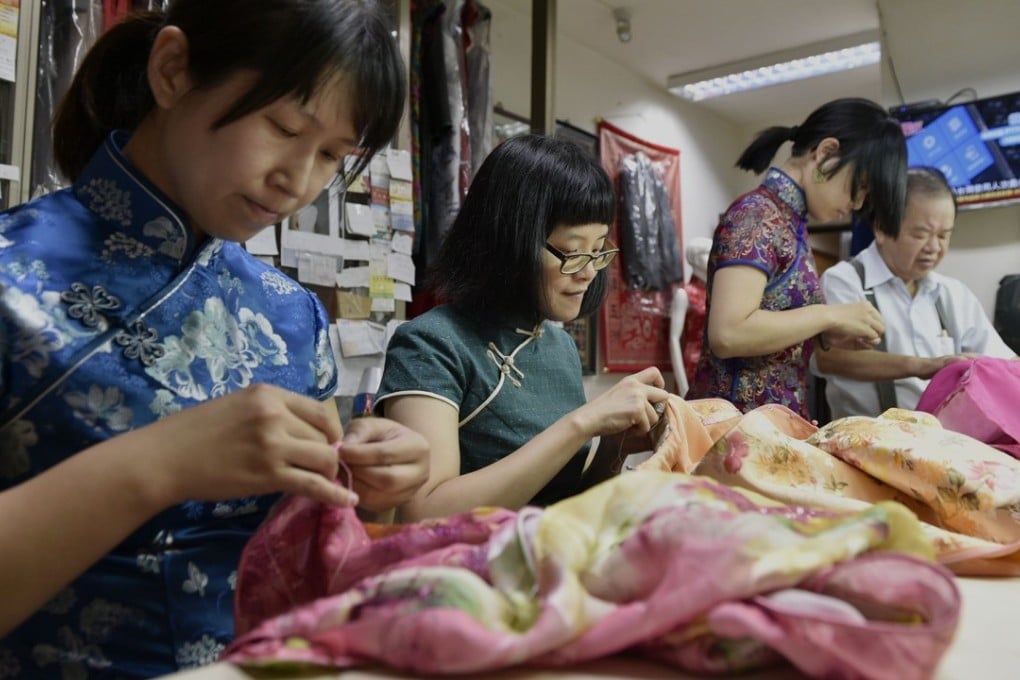 Taiwanese qipao maker Lin Chin-te (far right) works with his students at his studio in Taipei. Photo: AFP