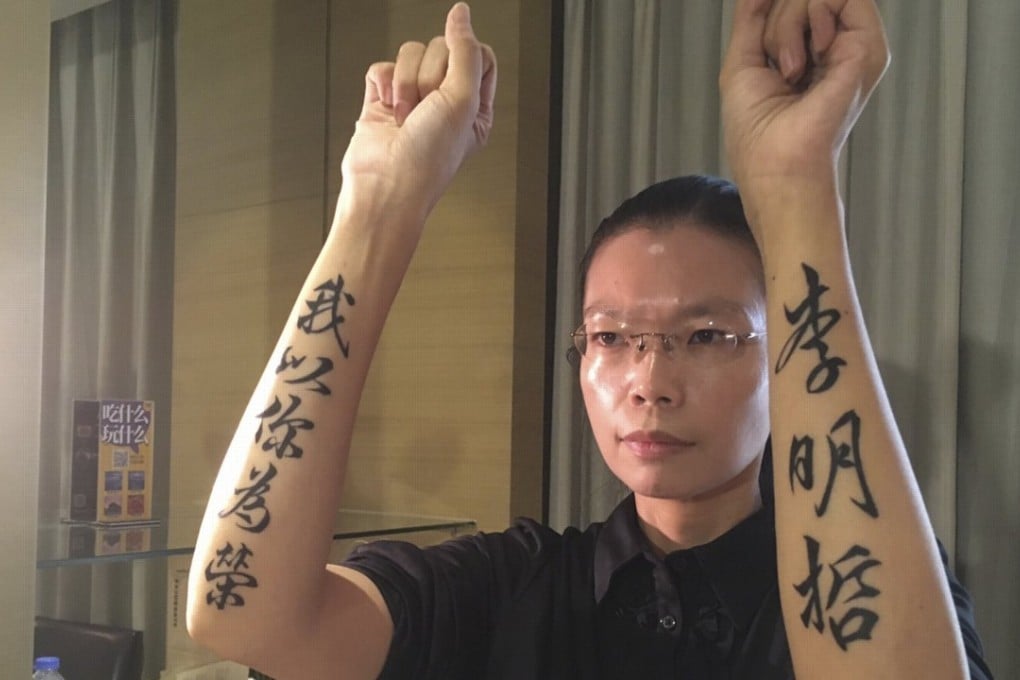 Lee Ching-yu shows tattoos on her arms reading “I am proud of you” (left) and her activist husband’s name “Lee Ming-che” (right). Photo: EPA