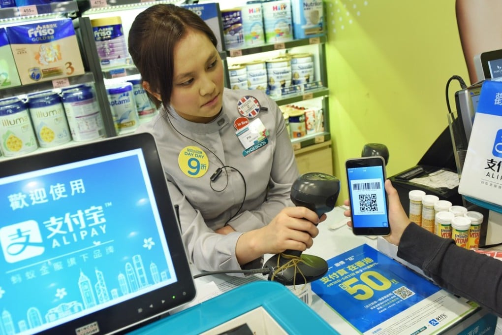 A shop assistant tests AlipayHK at a store in Hong Kong after its launch in May. Photo: Xinhua