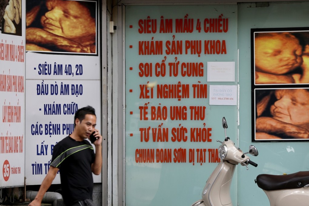 A man walks past a private clinic offering 4D fetus imaging services in Hanoi, Vietnam. Photo: EPA