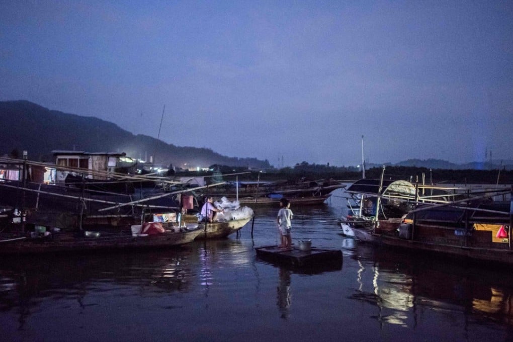 Children from the Tanka community ride a raft towards a moored boat in Datang, in southern China's Guangdong province. Photo: AFP