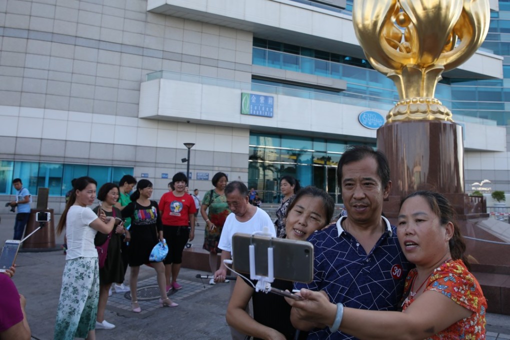 Mainland tourists at Golden Bauhinia Square in Wan Chai. An extended holiday on the mainland is expected to bring double the amount of tour groups next week. Photo: Sam Tsang