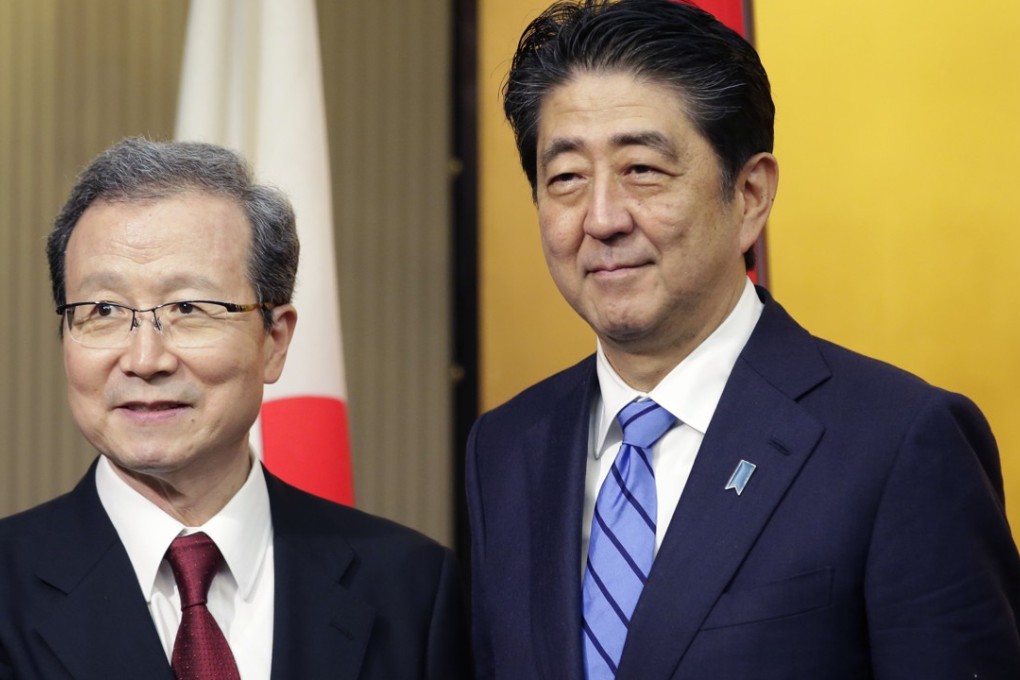 Japanese Prime Minister Shinzo Abe, right, poses with Chinese Ambassador to Japan Cheng Yonghua during a reception of China's National Foundation day and 45th-anniversary of Japan-China bilateral relations at a hotel in Tokyo, Thursday, Sept. 28, 2017. (AP Photo/Shizuo Kambayashi)