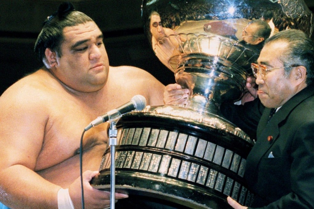 Sumo grand champion Musashimaru receiving the Emperor's Cup from Japanese prime minister Keizo Obuchi in 1993.Photo: Reuters