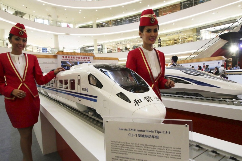 Attendants pose for a photo beside the models of a high-speed train during the China High Speed Railway on Fast Track exhibition in Jakarta, Indonesia. China is competing for a contract to build a high-speed railway connecting Singapore and Malaysia. Photo: Reuters