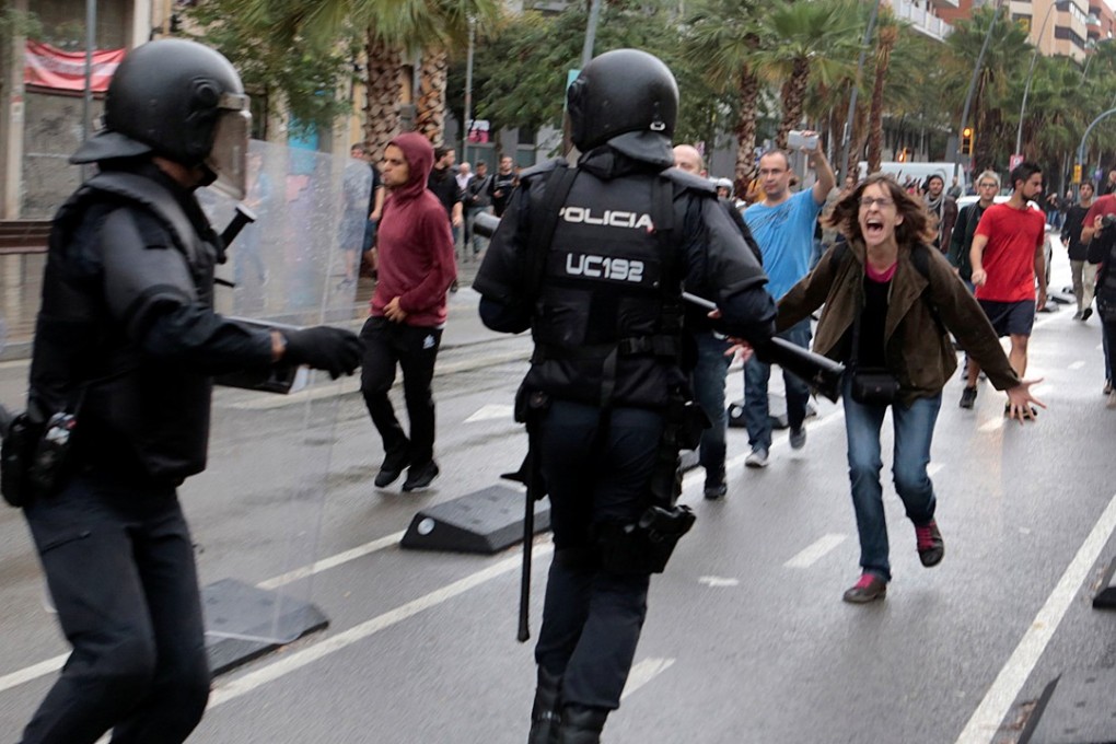 A woman yells at riot police near a polling station for the banned independence referendum in Barcelona, Spain. Photo: Reuters