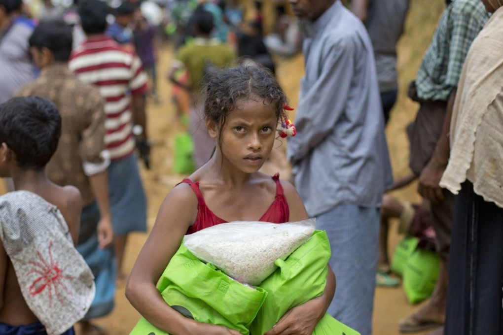 A newly arrived Rohingya girl carries food rations in Kutupalong, Bangladesh. Photo: AP
