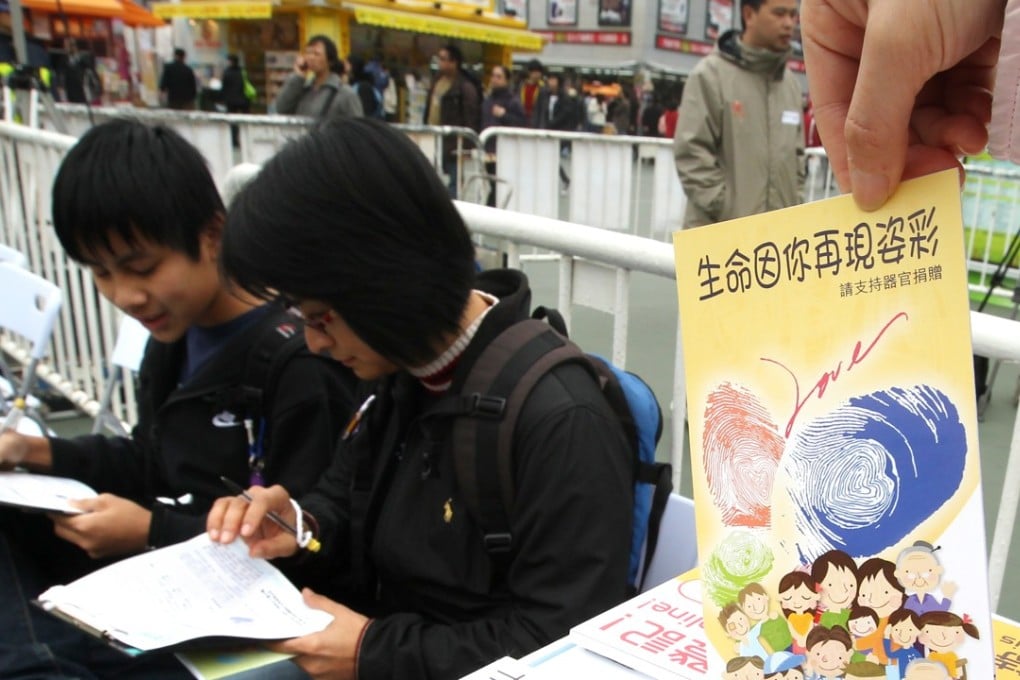 Members of the public sign donation cards during an organ donor drive held by the Department of Health. Photo: Felix Wong