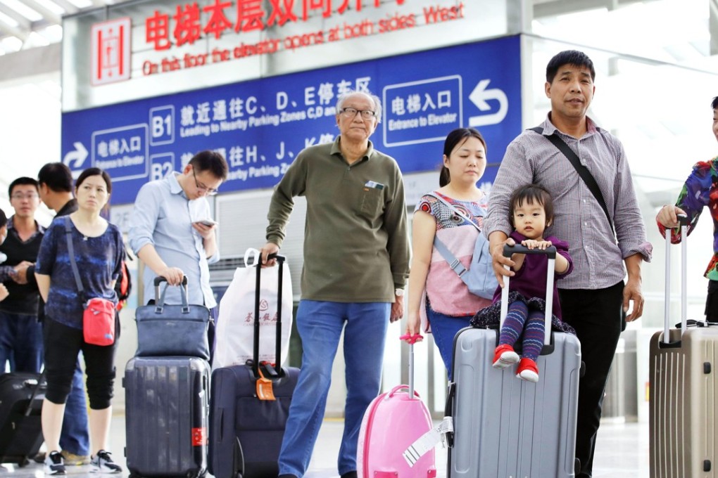 Travellers line up to head off on holidays at Beijing Capital International Airport on Sunday. Photo: Kyodo