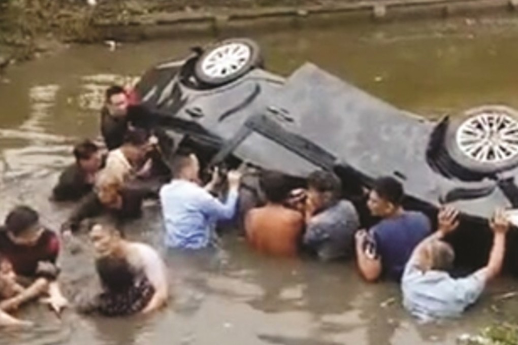 Villagers jumped into the river to free the family from their overturned vehicle. Photo: Yangtse Evening Post