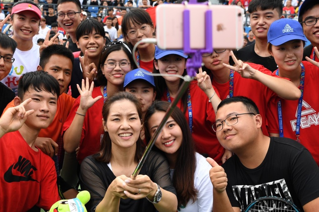 China’s two-time grand slam champion, Li Na, takes selfies with young tennis players during the 2017 WTA Wuhan Open. Photo: Xinhua