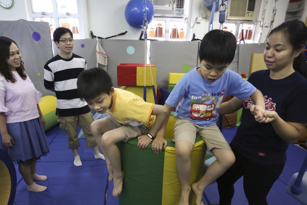 From left: Wu Kit-man and Yeung Kwok-wai with their twins Ho-kit (yellow T-shirt) and Ho-chun and instructor Lee Lai-yee at the Louis Program Training Centre in Yau Ma Tei. Photo: Jonathan Wong