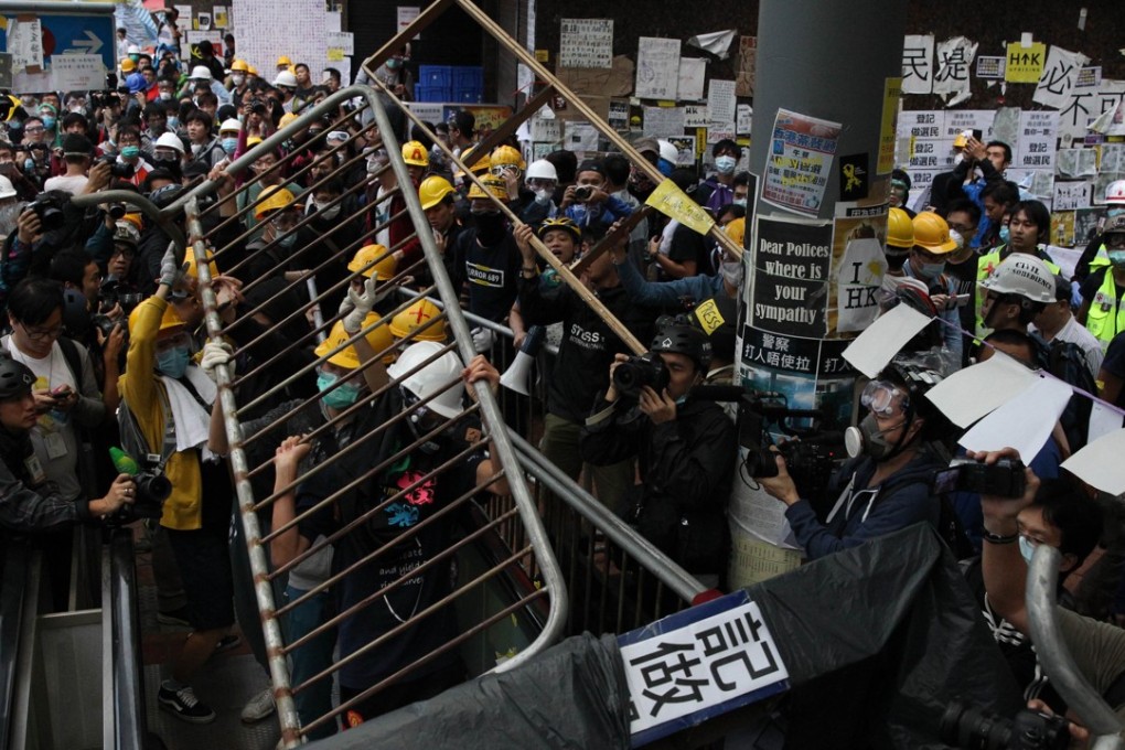 Pro-democracy protesters lift barricade reinforcements up onto an escalator near the government headquarters in Admiralty during the Occupy movement in 2014 as police and students clash. AFP PHOTO / DALE de la REY