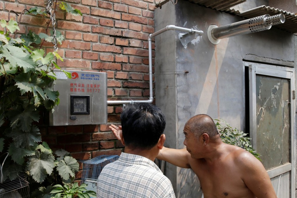 Yao Guanghui, right, and his neighbour examine the new gas meter installed in his house in Xiaozhangwan on the outskirts of Beijing. Photo: Reuters