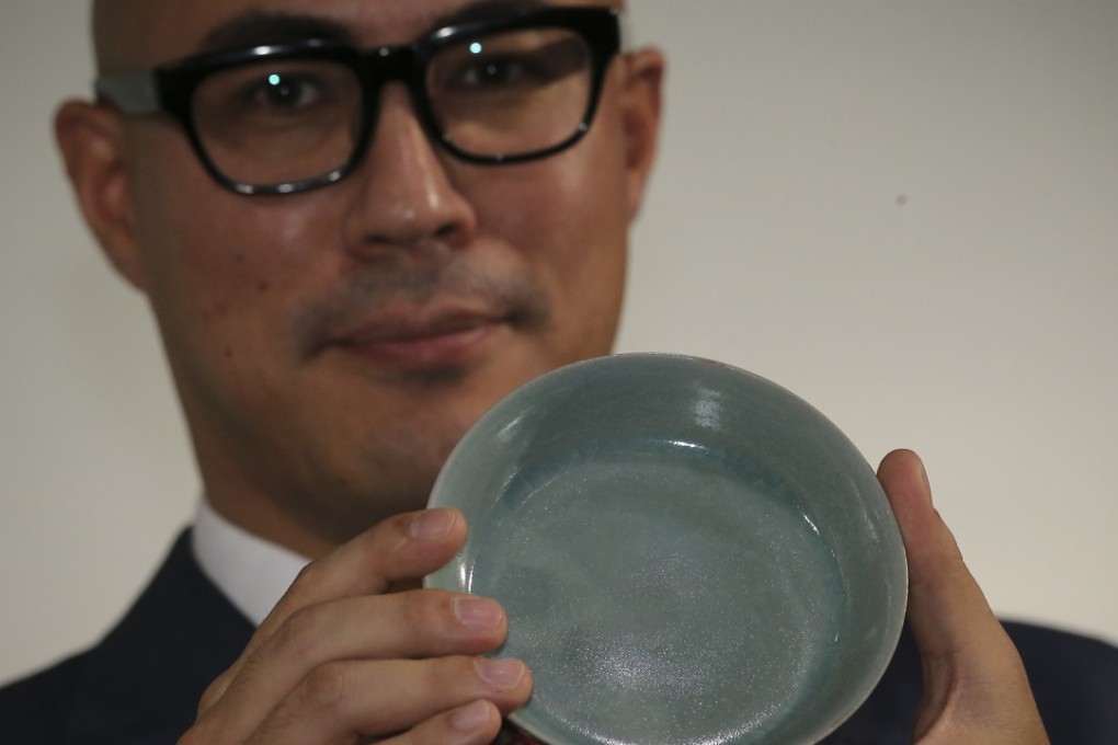 Nicolas Chow, deputy chairman of Sotheby's Asia, holds the Northern Song dynasty brush washer sold for HK$294.3 million, a new auction record for Chinese ceramics. Photo: Dickson Lee