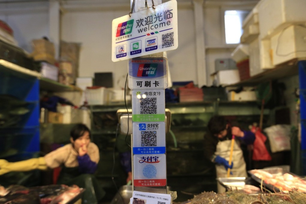Electronic payment options on offer at a seafood market in Beijing. A report by the UN’s trade and development body sees e-payment overtaking credit cards as the most popular way to pay in e-commerce by 2019. Photo: EPA